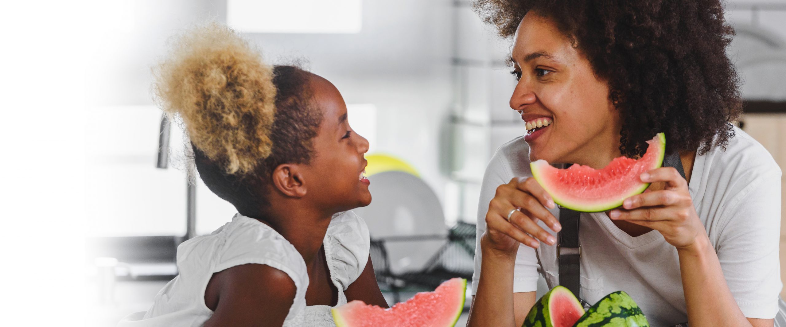 Mother and Daughter smiling while eating watermelons