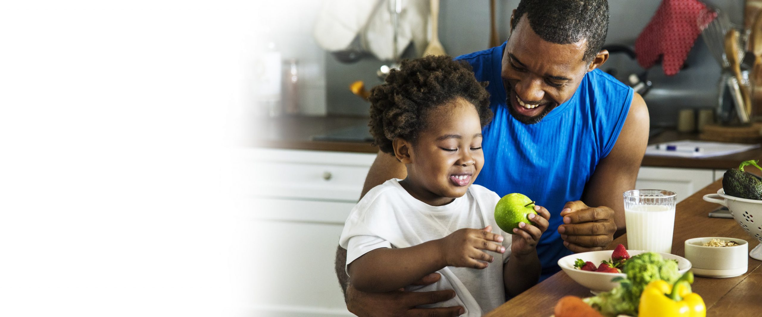 Father giving his daughter an apple at the table