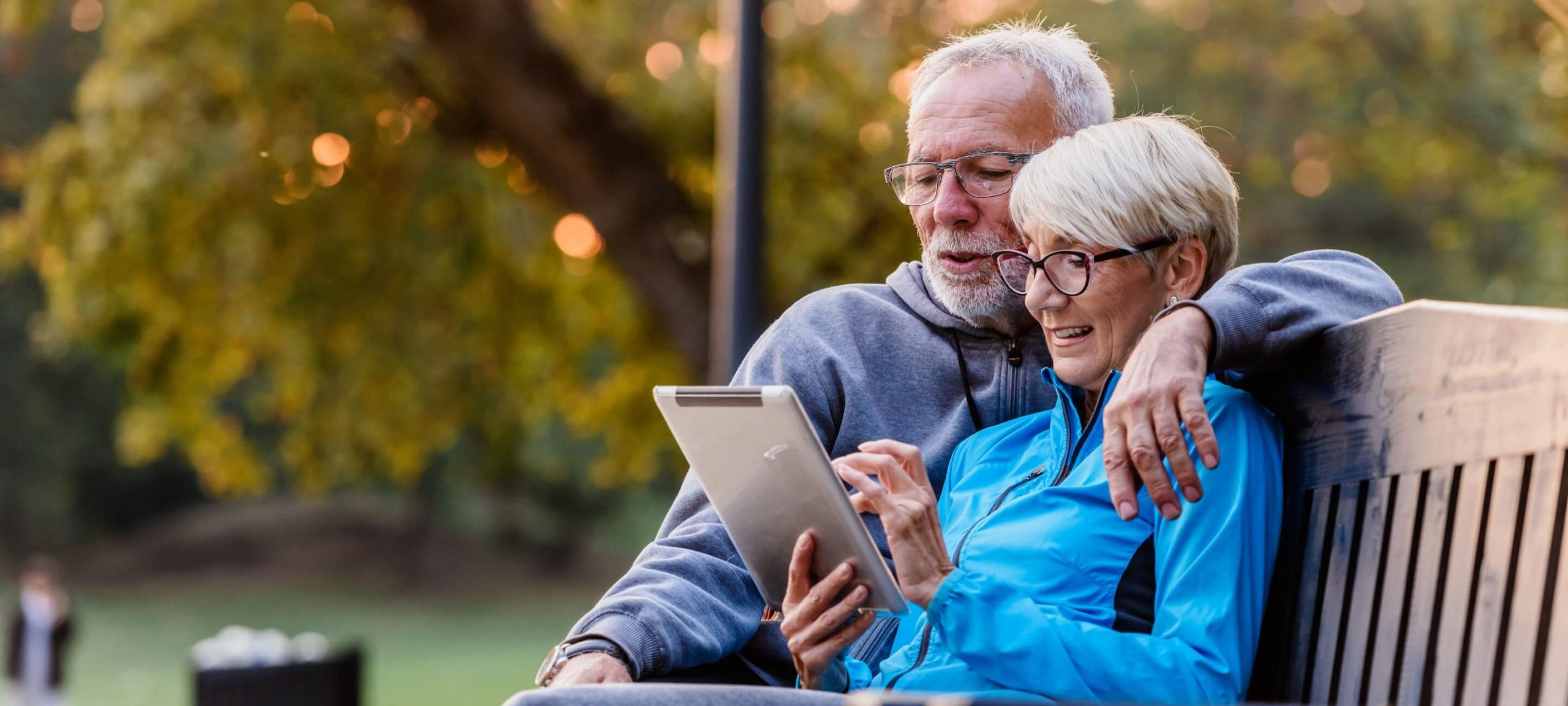 Couple sitting on a bench to leave a review on an iPad